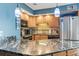 A kitchen features granite countertops, wooden cabinetry, and sleek stainless steel appliances at 1801 N Ocean Blvd. # O-4, North Myrtle Beach, SC 29582