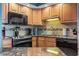 A kitchen with granite countertops, black appliances and wooden cabinetry provides ample storage at 1801 N Ocean Blvd. # O-4, North Myrtle Beach, SC 29582