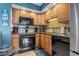 A kitchen featuring wooden cabinetry, black appliances and granite countertops at 1801 N Ocean Blvd. # O-4, North Myrtle Beach, SC 29582