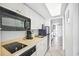 Practical kitchenette with white cabinets, black appliances, and a view towards the hallway and rooms at 201 74Th Ave. N # 1128, Myrtle Beach, SC 29572
