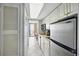 Galley kitchenette has white cabinets, stainless fridge, and microwave with easy access to the balcony at 201 74Th Ave. N # 1128, Myrtle Beach, SC 29572