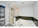 Bathroom with a glass shower, soaking tub with granite surround, and storage shelves at 2151 Bridge View Ct. # 1-702, North Myrtle Beach, SC 29582