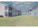 View of a two-story apartment building with screened-in balconies, surrounded by a well-manicured green lawn at 221 Port Smith Dr. # 6, Myrtle Beach, SC 29588