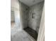 New bathroom features a gray tiled shower with a built-in seat and pebble floor at 2309 Seaseeker Ln., Myrtle Beach, SC 29577