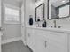 Bright bathroom with double vanity, quartz countertop, modern fixtures and gray tile flooring at 2309 Seaseeker Ln., Myrtle Beach, SC 29577