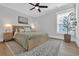 Neutral bedroom features a wood bed frame, patterned rug, and a large window providing natural light at 2309 Seaseeker Ln., Myrtle Beach, SC 29577