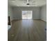 Large, bright living room with wood flooring, a ceiling fan, and sliding glass doors at 2309 Seaseeker Ln., Myrtle Beach, SC 29577