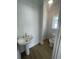 Bright powder room with white vertical paneling, light wood floor, pedestal sink and toilet at 2309 Seaseeker Ln., Myrtle Beach, SC 29577