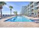 Relaxing outdoor pool area with palm trees, lounge chairs, and ocean views at 2311 S Ocean Blvd. # 144, Myrtle Beach, SC 29577