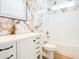 Modern bathroom features marble wall accents, white vanity with bronze fixtures, and bath with a shower at 232 Ole Maple St., Loris, SC 29569