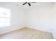 Bright bedroom featuring light wood-look floors, a ceiling fan, and a window at 232 Ole Maple St., Loris, SC 29569