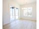 Bright dining room featuring light wood-look floors, sliding glass doors, and a modern chandelier at 232 Ole Maple St., Loris, SC 29569