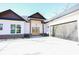 Exterior view of a charming home with a black roof and wood accents surrounding the front door and garage at 232 Ole Maple St., Loris, SC 29569