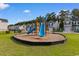 Community playground with blue slides, climbing structures, and safety mulch surrounded by a black fence at 247 Christiana Ln. # D, Myrtle Beach, SC 29579