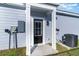 A back door is framed by white columns on a light blue home, with an adjacent AC unit and electrical meter at 2604 Willow St., North Myrtle Beach, SC 29582