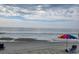Picturesque beach scene featuring beach chairs and an umbrella under a partly cloudy sky at 2604 Willow St., North Myrtle Beach, SC 29582