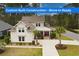 Beautiful two-story home featuring a spacious driveway, lush landscaping, and a welcoming front porch entrance at 2935 Moss Bridge Ln., Myrtle Beach, SC 29579