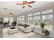 Relaxing sun room featuring neutral colors, a ceiling fan, large windows, and a comfortable seating area at 2935 Moss Bridge Ln., Myrtle Beach, SC 29579