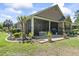 Home exterior featuring a lush backyard with a screened-in porch and manicured landscaping at 320 Cog Hill Ct., Murrells Inlet, SC 29576