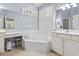 A Primary bathroom featuring a corner tub, dual vanities, a makeup vanity, and soft blue walls at 320 Cog Hill Ct., Murrells Inlet, SC 29576