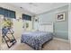 This is a cozy bedroom with blue and yellow decor, a ceiling fan, and large windows at 320 Cog Hill Ct., Murrells Inlet, SC 29576