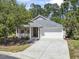 Charming single-story home featuring a two-car garage, front porch and well-manicured lawn at 320 Cog Hill Ct., Murrells Inlet, SC 29576