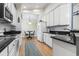 Well-equipped kitchen leading into dining area, featuring black granite countertops and white cabinetry at 320 Cog Hill Ct., Murrells Inlet, SC 29576