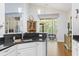 Well-lit kitchen featuring granite countertops, white cabinets, and views to the outside at 320 Cog Hill Ct., Murrells Inlet, SC 29576