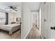 Bright bedroom featuring hardwood floors and ceiling fan adjacent to hallway at 404 75Th Ave. N # E, Myrtle Beach, SC 29572