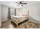 Bedroom featuring a queen-sized bed, dark wood flooring, ceiling fan, and window at 404 75Th Ave. N # E, Myrtle Beach, SC 29572