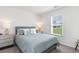 Comfortable bedroom with soft blue bedding, window view, and coordinating furniture, ideal for relaxation at 417 Flank St., Myrtle Beach, SC 29588