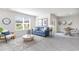 Sunlit living room featuring a comfortable blue sofa, large window, and modern decor with an adjacent dining area at 417 Flank St., Myrtle Beach, SC 29588