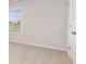 A bright bedroom features neutral carpeting, a window with blinds, and a closed white door at 425 Flank St., Myrtle Beach, SC 29588