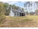 A well-maintained backyard featuring a screen porch and lush lawn, surrounded by mature trees at 480 N Boundaryline Dr. Nw, Calabash, NC 28467