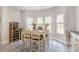 Cozy dining area with light gray wood flooring, a wine rack, and natural light from multiple windows at 480 N Boundaryline Dr. Nw, Calabash, NC 28467