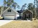 Charming home featuring a two-car garage, stone accents, and complemented by a beautifully landscaped front yard at 480 N Boundaryline Dr. Nw, Calabash, NC 28467