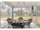 Screened-in porch showcasing wicker chairs, fire pit table, and string lights at 480 N Boundaryline Dr. Nw, Calabash, NC 28467