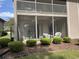 The screened-in back porch features a ceiling fan, wicker furniture, and a view of the yard at 524 Pinehurst Ln. # 19D, Pawleys Island, SC 29585