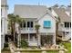 Inviting two-story white beach house with dual balconies and outdoor living, landscaped with attractive palm trees at 5361 Ocean Village Dr., Myrtle Beach, SC 29577