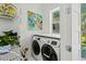 Well-lit laundry room featuring a modern washer and dryer with white cabinets and bright accents at 5361 Ocean Village Dr., Myrtle Beach, SC 29577