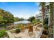Inviting outdoor patio with wooden chairs overlooking a tranquil lake and lush greenery at 5361 Ocean Village Dr., Myrtle Beach, SC 29577