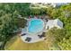 Aerial view of a community pool area with lounge chairs and a covered patio space surrounded by lush greenery at 5361 Ocean Village Dr., Myrtle Beach, SC 29577