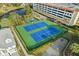 Overhead view of the community tennis and basketball courts with adjacent pond, foliage, and parking at 5361 Ocean Village Dr., Myrtle Beach, SC 29577