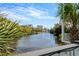 Relaxing view of a canal with palm trees and buildings in the distance under a blue sky at 5361 Ocean Village Dr., Myrtle Beach, SC 29577