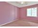 This empty pink bedroom features a ceiling fan and a single window at 5525 Springs Ave., Myrtle Beach, SC 29577
