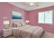 This pink bedroom has a decorative bed with lamps on both sides and a window at 5525 Springs Ave., Myrtle Beach, SC 29577
