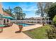 Backyard pool with surrounding patio, seating under a blue umbrella, white pergola, and green landscape at 5628 Marion Circle, Myrtle Beach, SC 29577