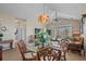 Dining area with a glass table, chandelier, and sliding glass doors that fill the room with natural light at 5751 Oyster Catcher Dr. # 234, North Myrtle Beach, SC 29582