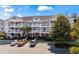 Three-story condo building with white railings, exterior stairs, and a well-maintained parking lot and landscaping at 5751 Oyster Catcher Dr. # 234, North Myrtle Beach, SC 29582