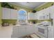 Well-lit kitchen featuring white cabinetry, modern appliances, and a charming arched window above the sink at 5751 Oyster Catcher Dr. # 234, North Myrtle Beach, SC 29582